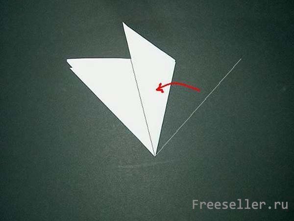 Процесс вырезания снежинки из бумаги