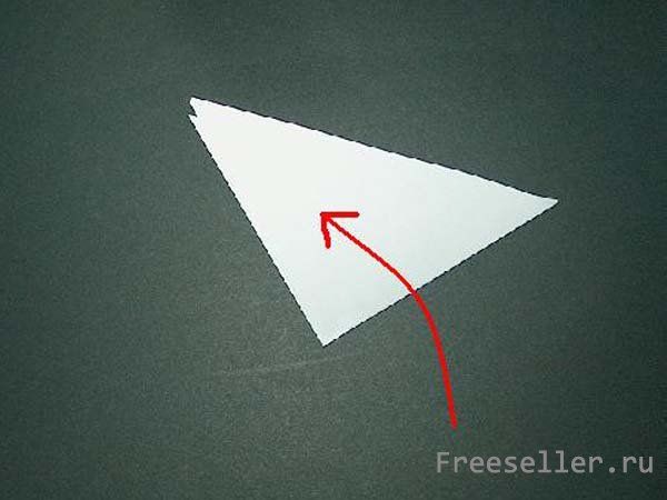 Процесс вырезания снежинки из бумаги