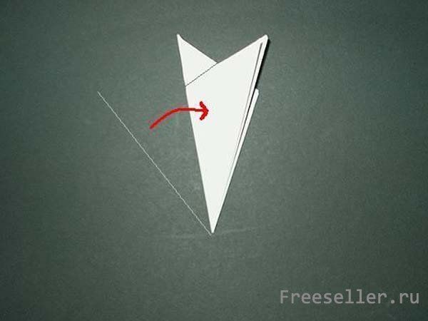 Процесс вырезания снежинки из бумаги