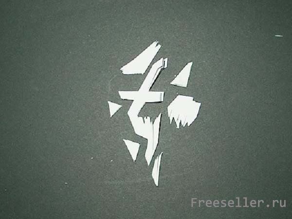 Процесс вырезания снежинки из бумаги