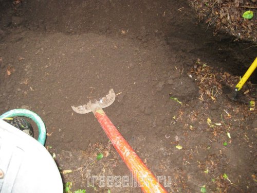 погрузка земли в тачку лопатой