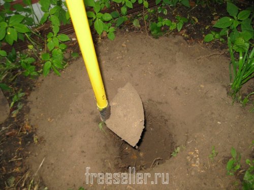 Извлекаем землю из ямы при помощи тяпки