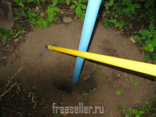 Извлекаем землю из ямы при помощи тяпки и лопаты
