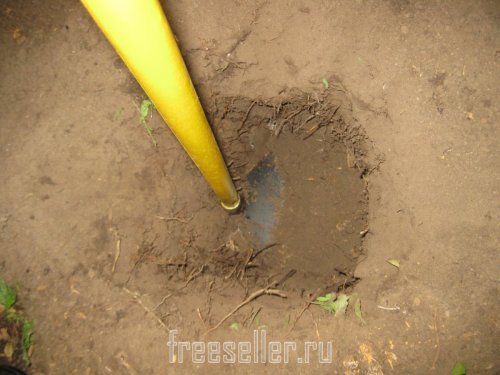 Извлекаем землю из ямы при помощи тяпки