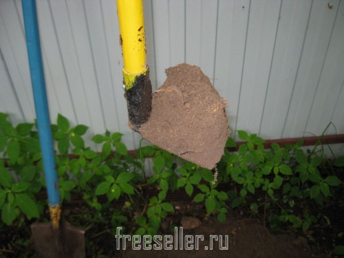 Извлекаем землю из ямы при помощи тяпки