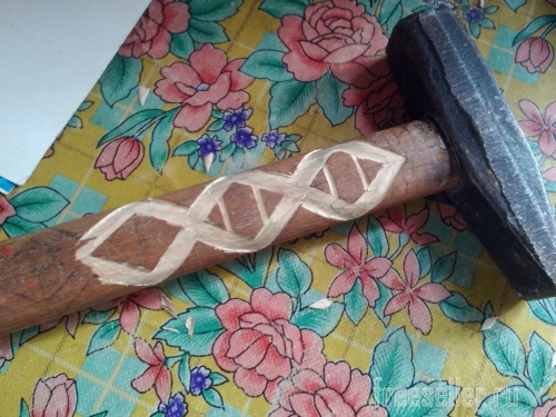 Процесс вырезания узора на рукоятке молотка