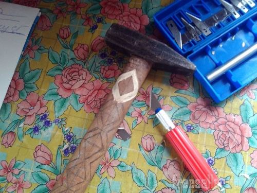 Процесс вырезания узора на рукоятке молотка